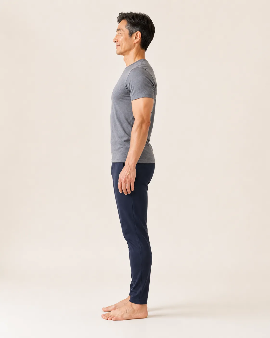 Side profile of an older adult standing with an open chest, shoulders back and head stacked over the body after towel method practice
